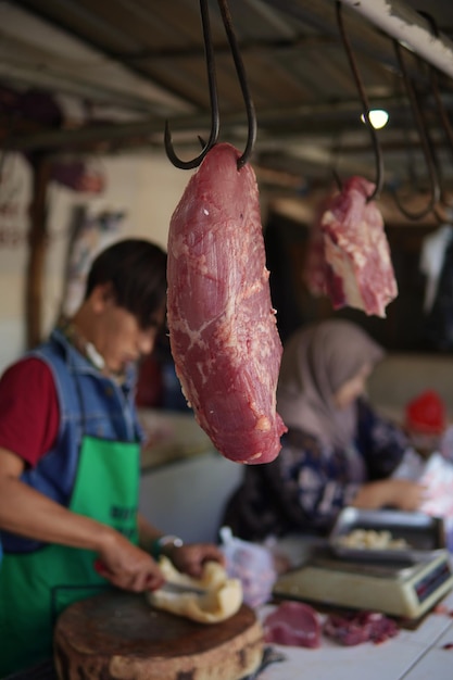 Entenda a Diferença entre Carnes Bovina, Suína e de Frango 1 Uma Cena De Mercado Tradicional Apresentando Vários Cortes De Carne Bovina Expostos Em Mesas De Madeira, Com Um Açougueiro E Clientes Interagindo Ao Fundo.