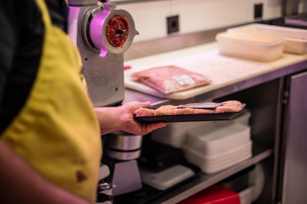 Como as Compras Online Estão Transformando o Mercado de Açougues em Uberlândia 1 As Mãos De Um Açougueiro Segurando Uma Bandeja De Nuggets De Frango Fresquinhos.