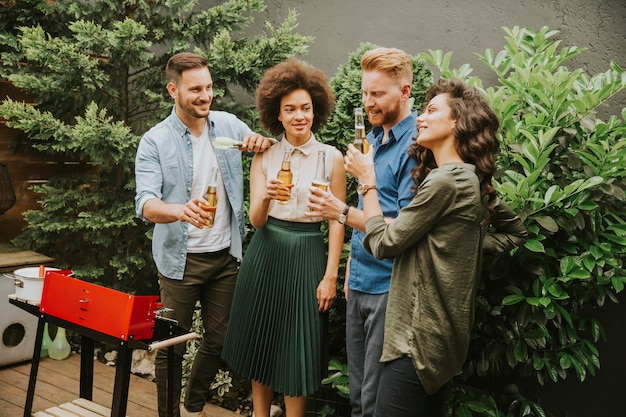 Como Planejar um Churrasco Perfeito com Carnes do Açougue do Nilo 1 Um Grupo De Amigos Se Reuniu Alegremente Ao Redor Da Churrasqueira, Cozinhando Comida E Desfrutando De Um Churrasco Ao Ar Livre.