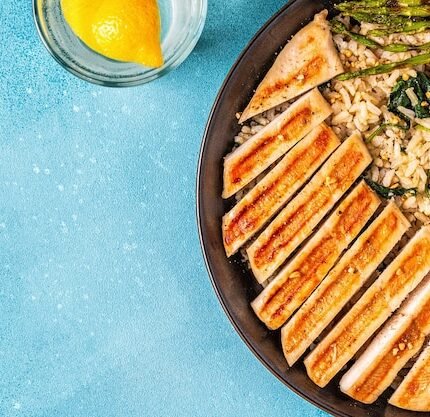 Uma Preparação De Refeições Vibrante Com Peito De Frango Grelhado Servido Com Arroz Integral, Espinafre, Brócolis E Aspargos, Destacando Um Conceito De Alimentação Saudável.